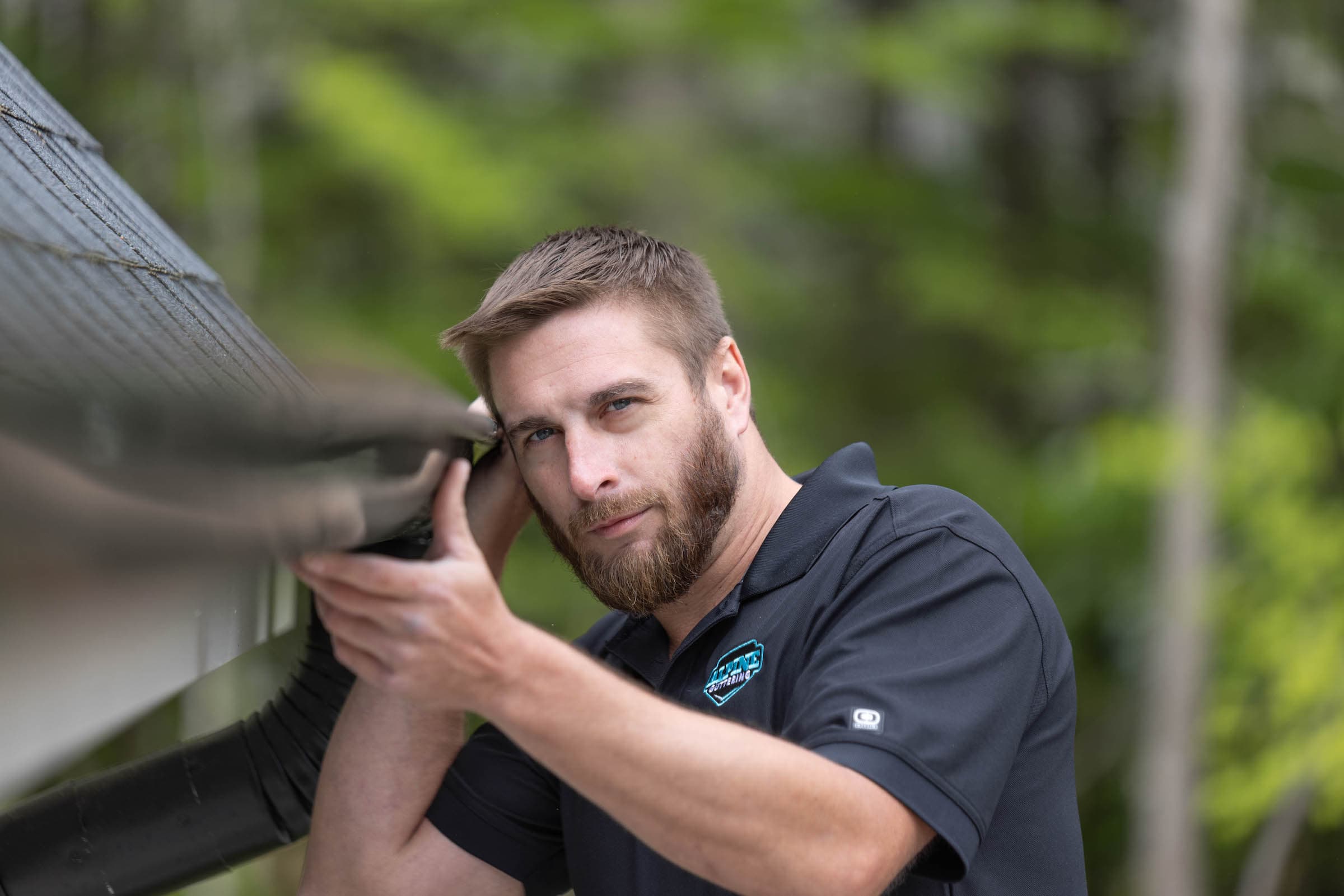 Man installing custom gutters - seamless gutter services near you in Williamsburg, VA